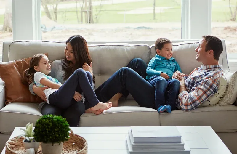family laughing on couch and having fun pest free home